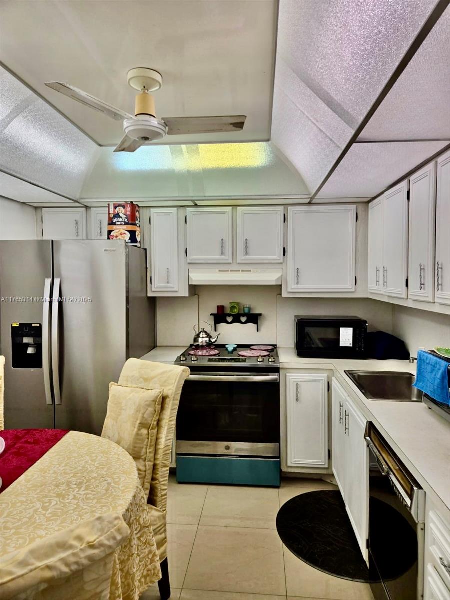 Boynton Beach Boynton Beach, FL 33435 - Photo 28 of 29 a kitchen with stainless steel appliances granite countertop a sink a stove a refrigerator and cabinets