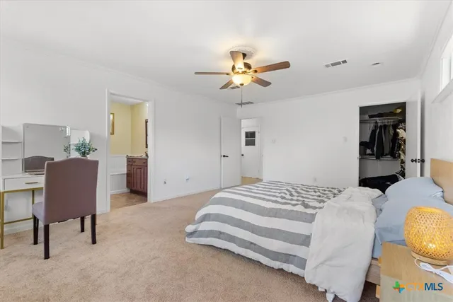 a spacious bedroom with a bed and a chandelier