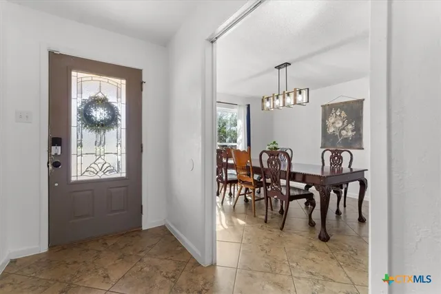 a view of a dining room with furniture and chandelier