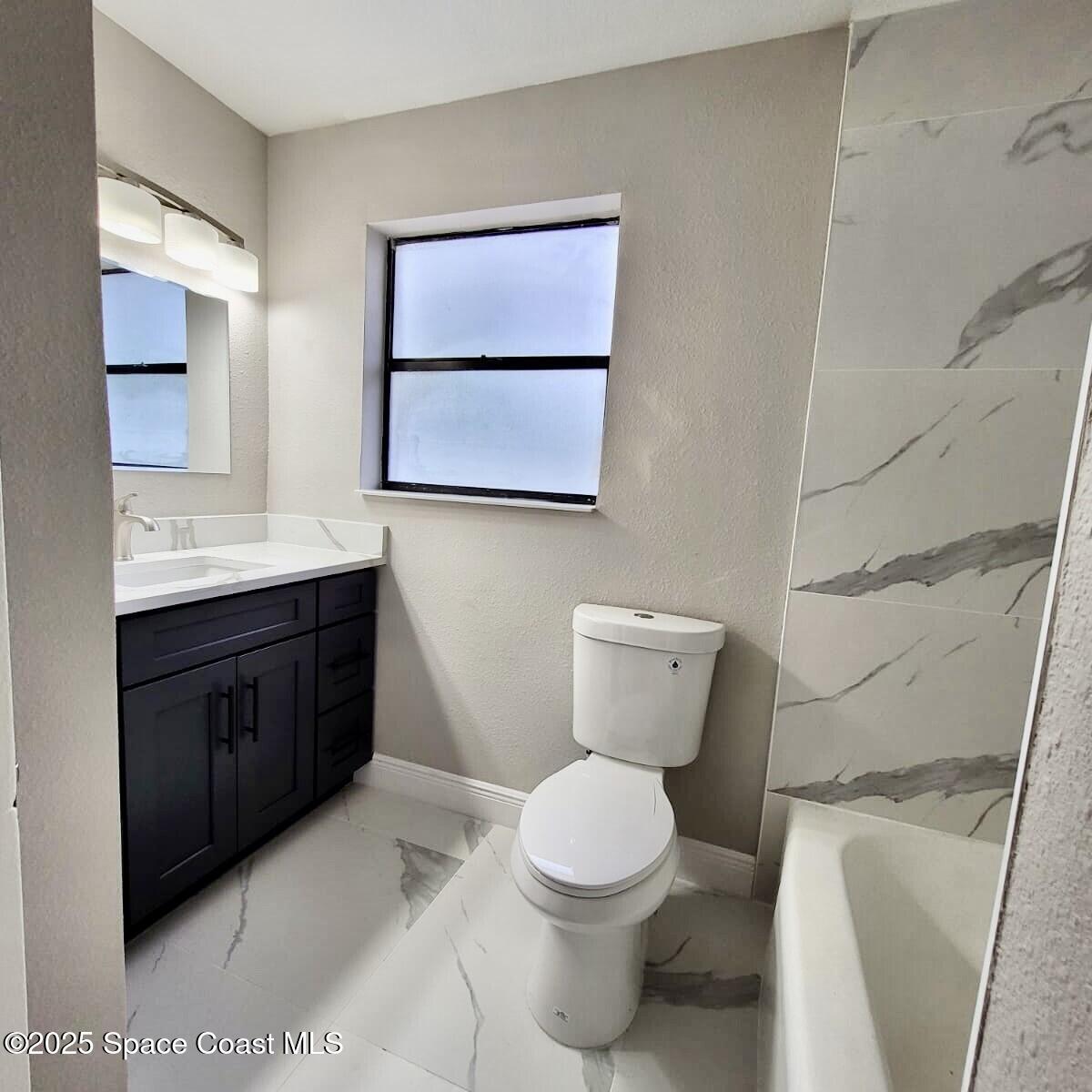 1510 Cambridge Drive Cocoa, FL 32922 - Photo 12 of 19 a bathroom with a toilet sink and mirror