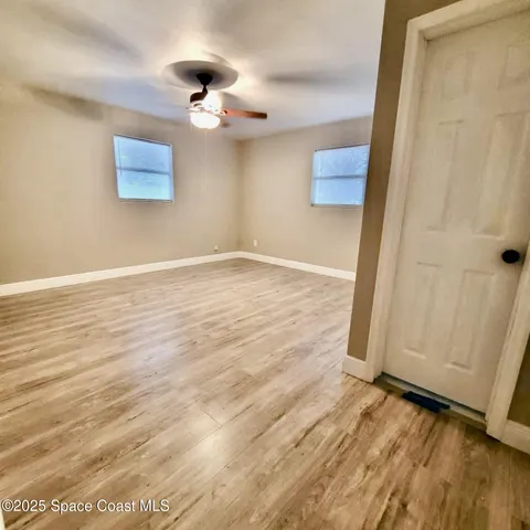 a view of an empty room with wooden floor