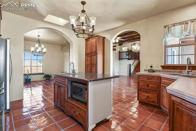 a large kitchen with stainless steel appliances granite countertop a stove and cabinets