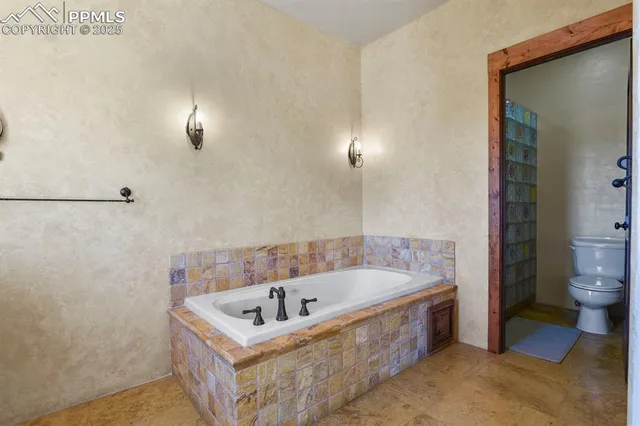 a bathroom with a tub a toilet and a sink