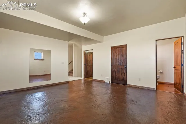 a view of an empty room with wooden floor and closet