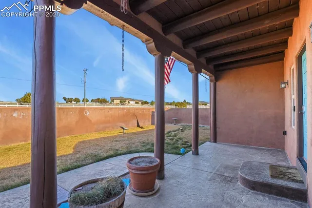 a view of a porch with a floor to ceiling window and wooden fence