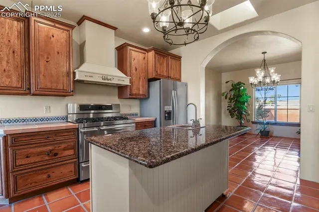 a kitchen with stainless steel appliances granite countertop a sink a stove and a wooden floors