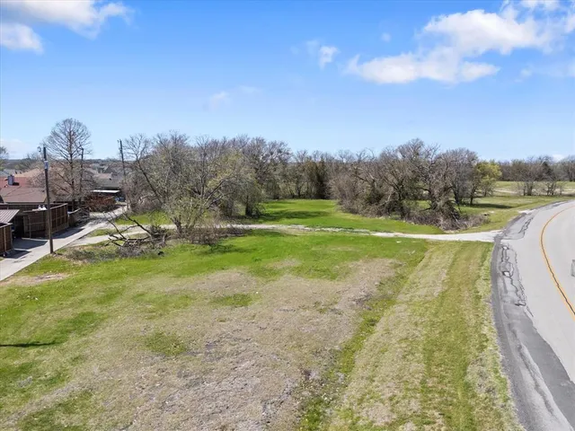 a view of a field of grass and trees