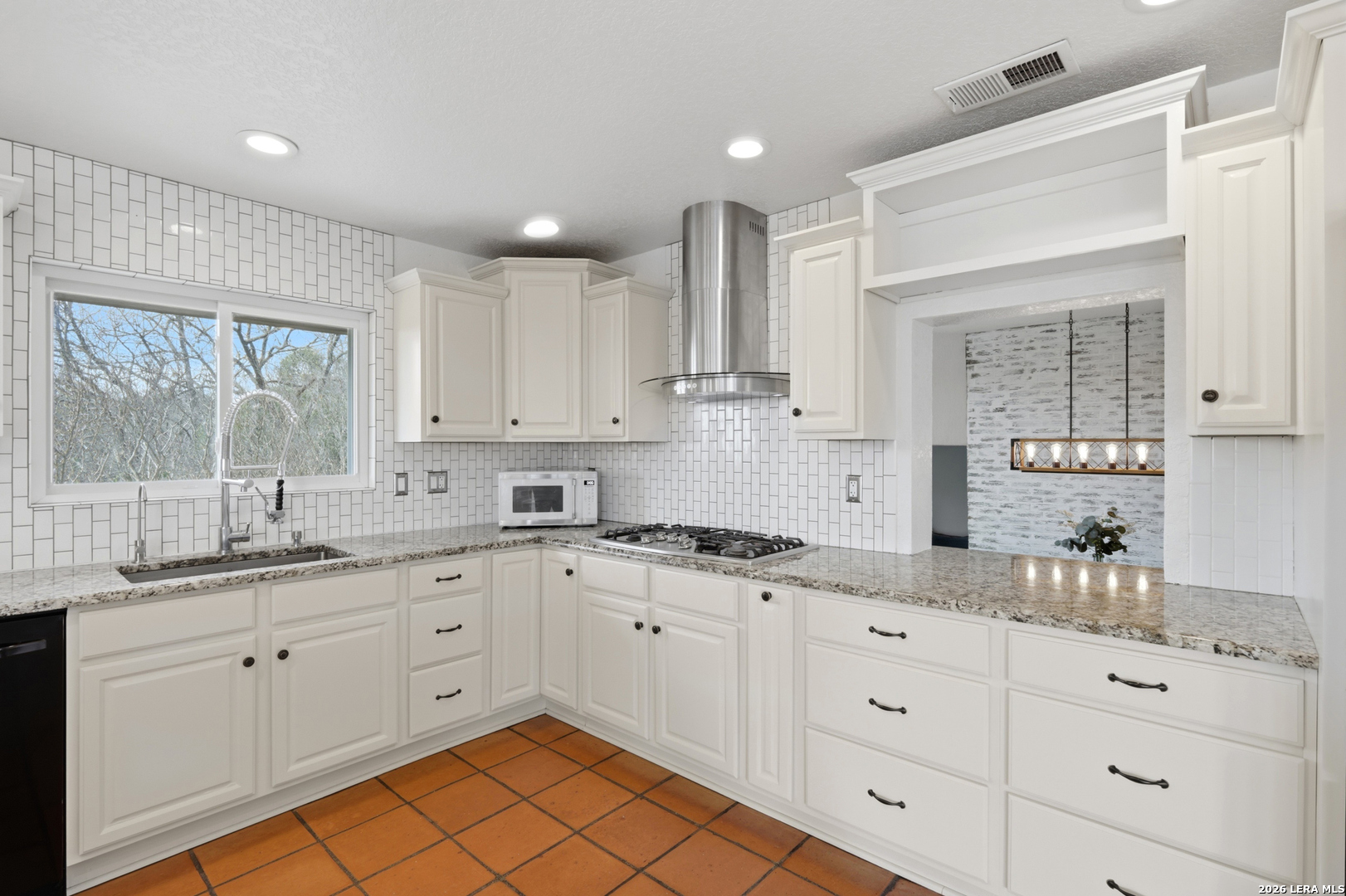10206 Rafter S Trail Helotes, TX 78023 - Photo 18 of 49 a kitchen with a sink dishwasher and white cabinets with wooden floor