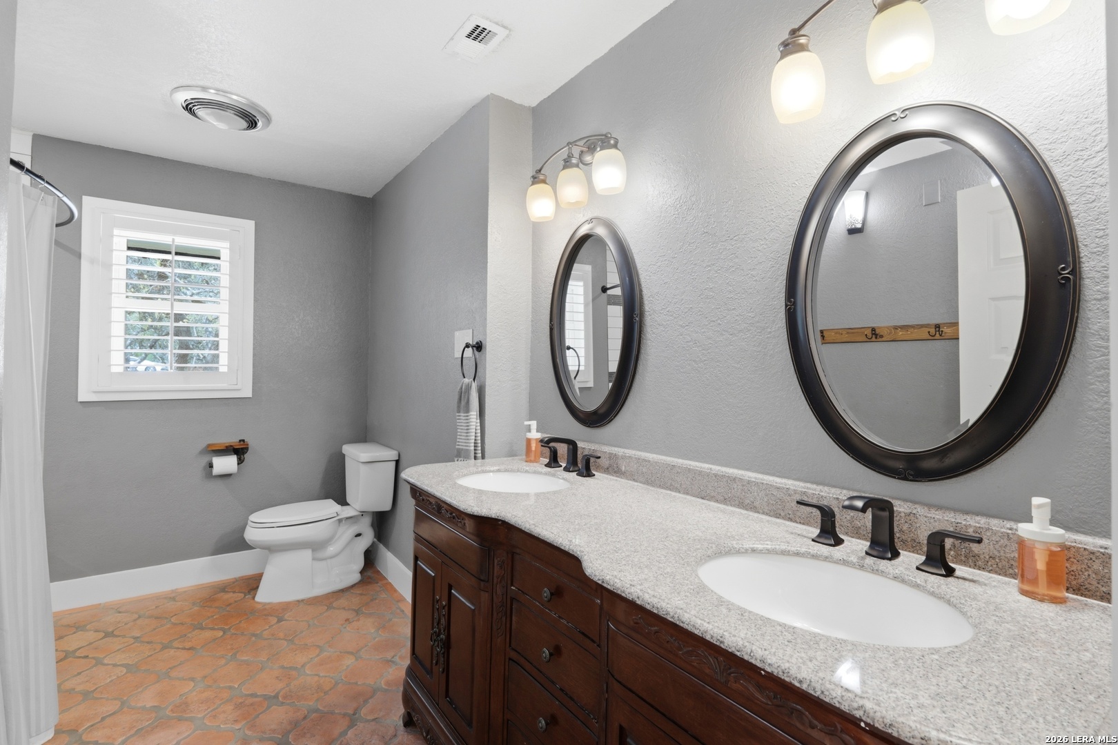 10206 Rafter S Trail Helotes, TX 78023 - Photo 28 of 49 a bathroom with 2 sink and a mirror