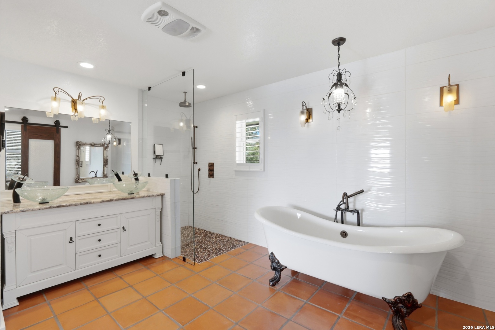 10206 Rafter S Trail Helotes, TX 78023 - Photo 31 of 49 a spacious bathroom with a double vanity sink a mirror and a bathtub