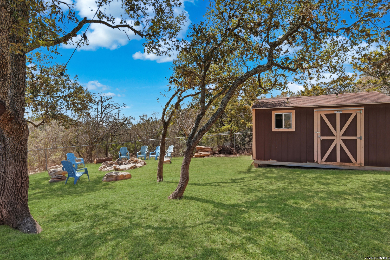 10206 Rafter S Trail Helotes, TX 78023 - Photo 37 of 49 a view of backyard with a table and chairs and a large tree