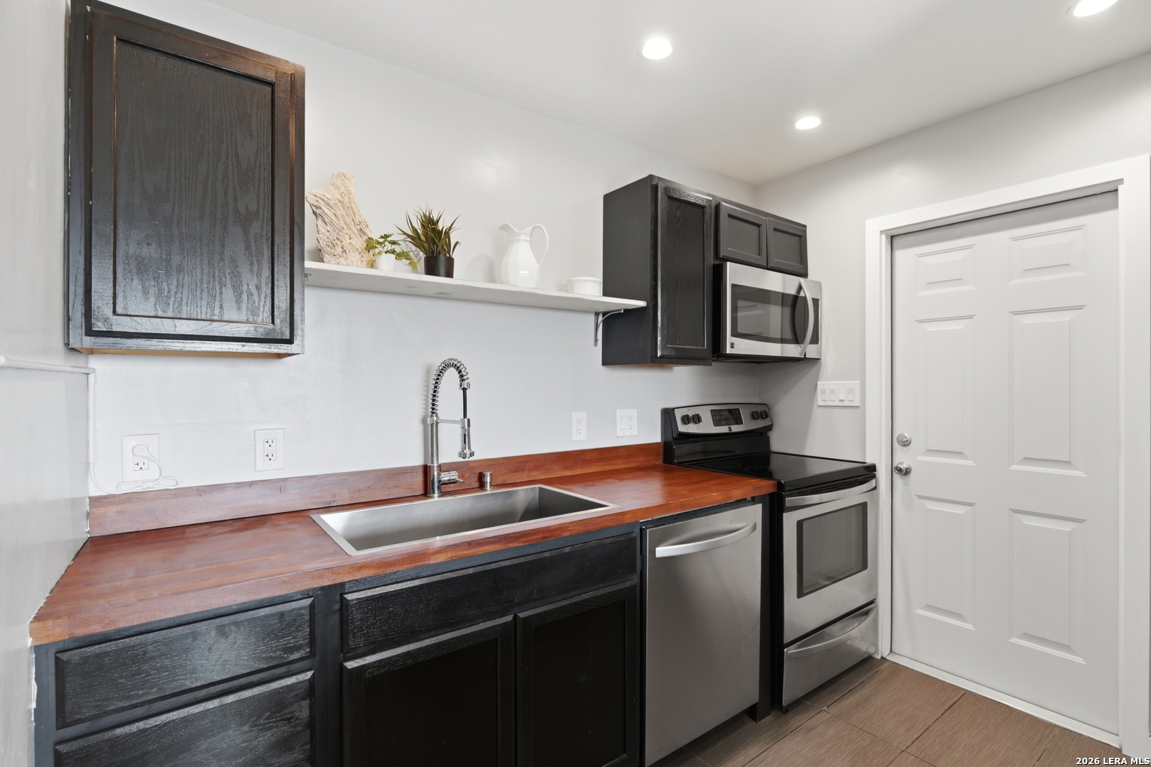 10206 Rafter S Trail Helotes, TX 78023 - Photo 43 of 49 a kitchen with stainless steel appliances granite countertop a sink stove and microwave