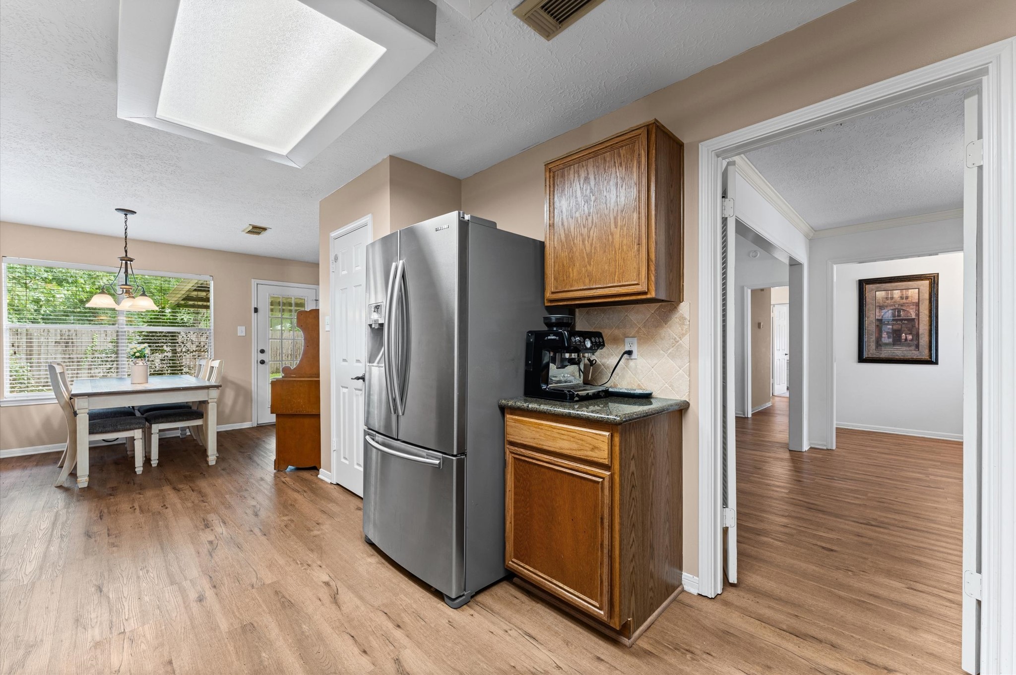 17618 Mill Springs Drive Spring, TX 77379 - Photo 9 of 26 This inviting kitchen features stainless steel appliances, wooden cabinetry, and a cozy breakfast nook with ample natural light from large windows. The open layout connects seamlessly to the dining area, creating a welcoming space for family gatherings.