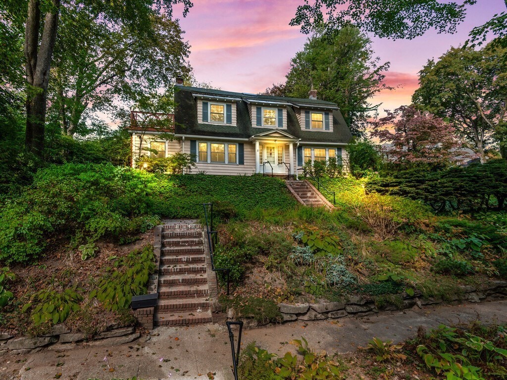 a front view of a house with a yard and trees
