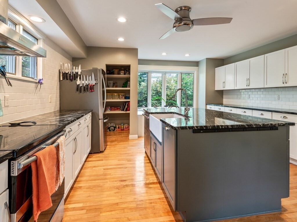 8 Montvale Road Worcester, MA 01609 - Photo 13 of 31 a kitchen with stainless steel appliances granite countertop a refrigerator a sink dishwasher a stove and a dining table with wooden floor