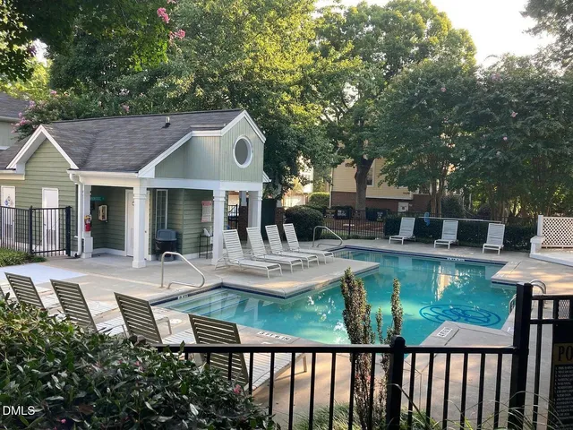 a patio with couches table and chairs and potted plants with wooden floor and fence