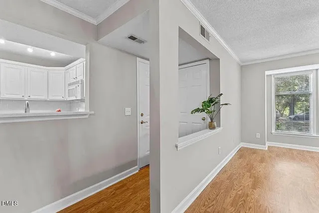 a view of a kitchen with wooden floor and a window