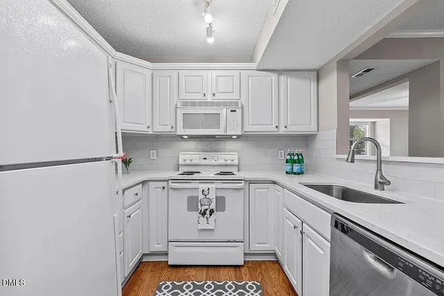 a kitchen with white cabinets and white appliances