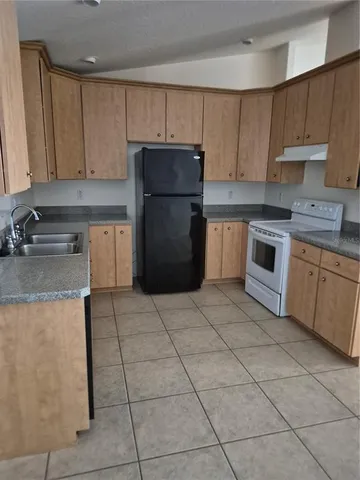 a kitchen with a stove a sink and a refrigerator