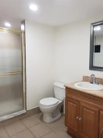 an empty room with wooden floor and fan