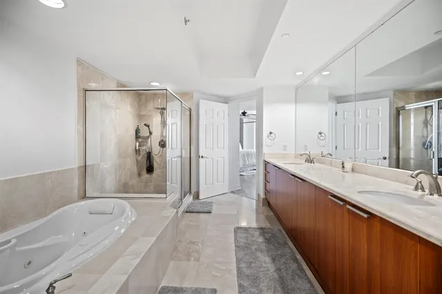 a spacious bathroom with a tub sink shower and mirror