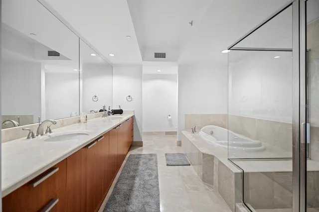 a spacious bathroom with a tub sink and mirror