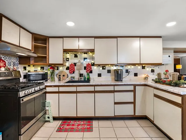 a kitchen with stainless steel appliances granite countertop a sink stove and cabinets