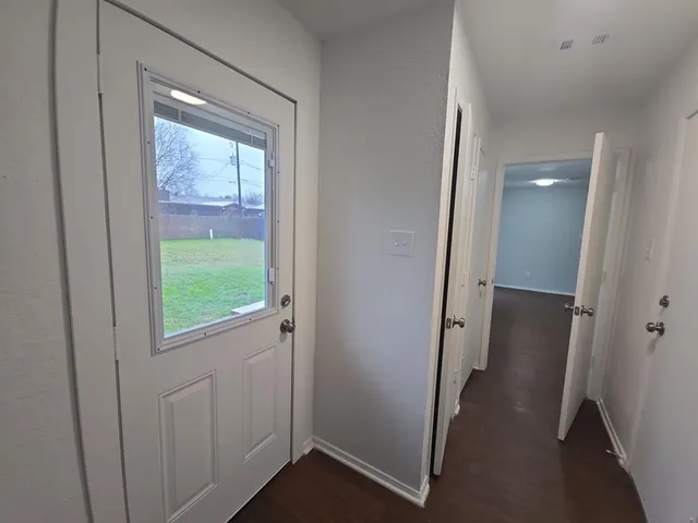 an entryway door with a hallway in the house