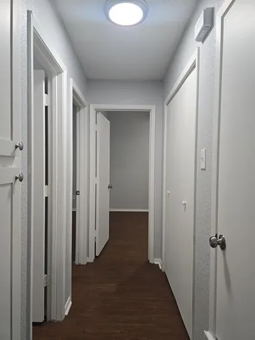 a view of a hallway with wooden floor