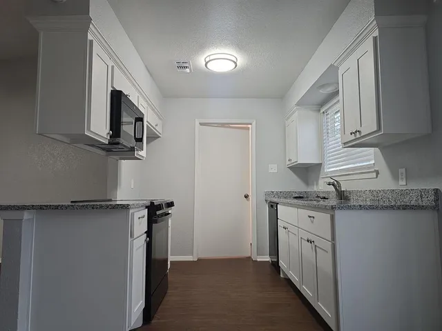 a kitchen with stainless steel appliances granite countertop a sink and a stove top oven