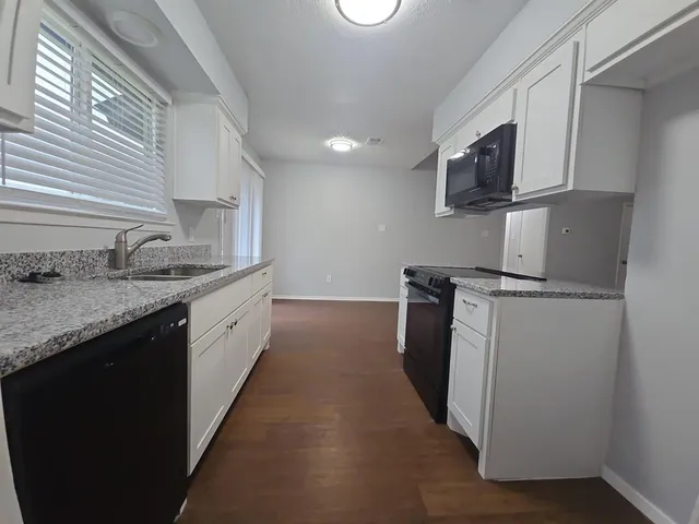 a kitchen with sink a microwave and cabinets