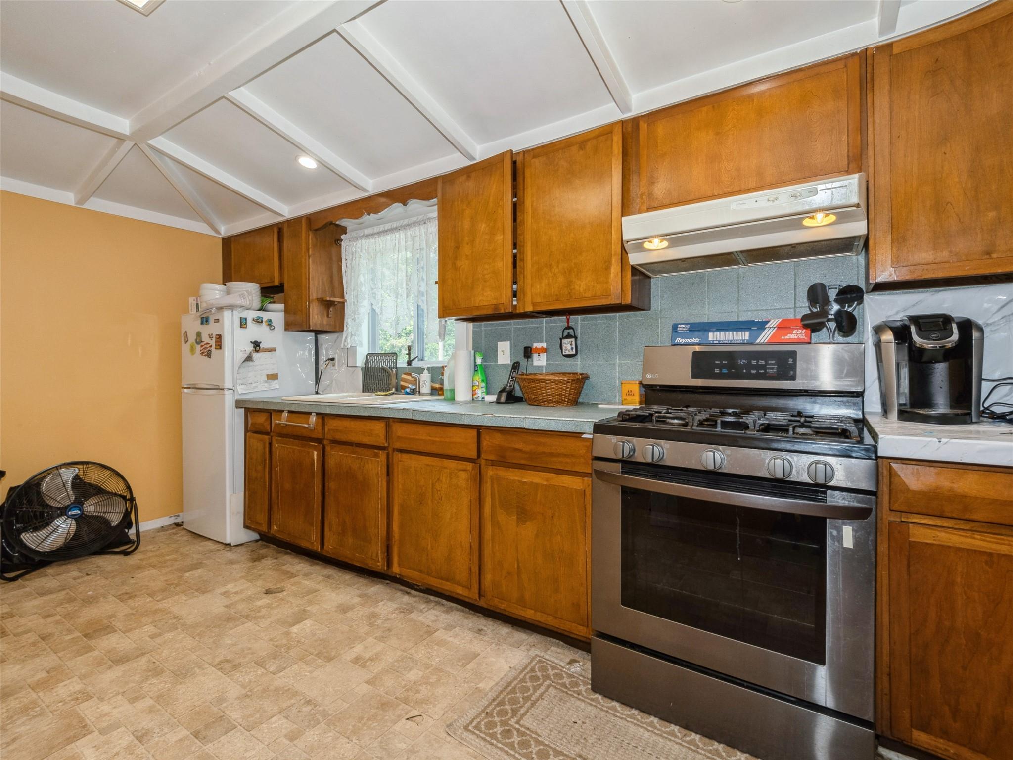 413 Vassar Road Poughkeepsie, NY 12603 - Photo 30 of 38 a kitchen with stainless steel appliances a stove a sink cabinets and a window