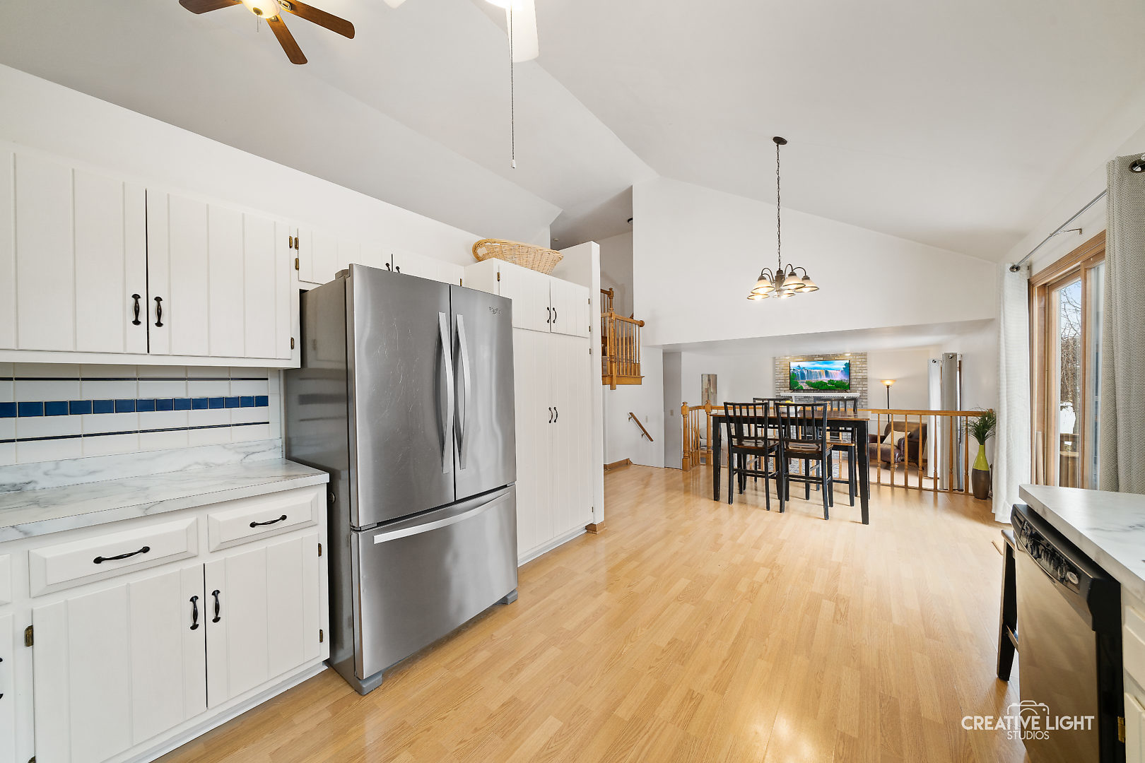 1714 Chestnut Hill Road Plainfield, IL 60586 - Photo 9 of 29 a kitchen with stainless steel appliances kitchen island granite countertop a refrigerator a stove a dining table and chairs with wooden floor