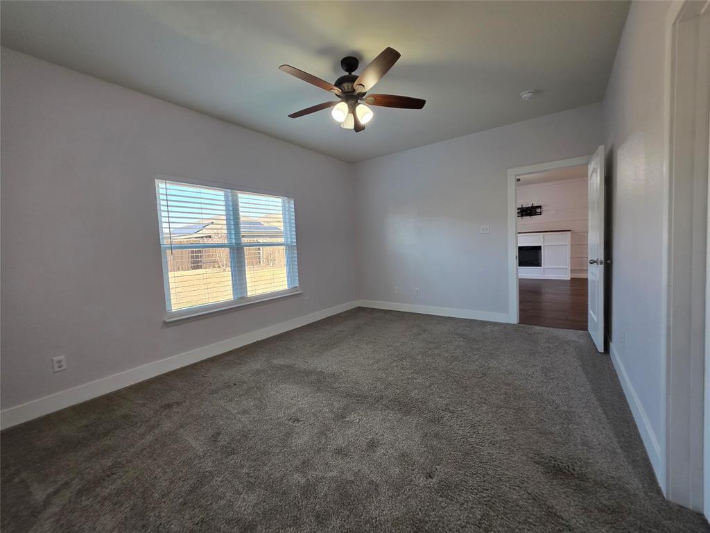 149 Ryan Street Anna, TX 75409 - Photo 16 of 38 an empty room with ceiling fan and windows