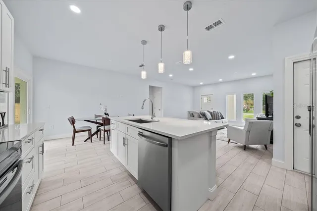 a kitchen with stainless steel appliances a sink a counter top space and cabinets