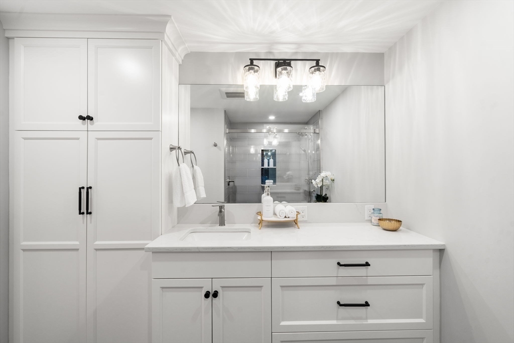 65 Grove Wellesley Ma, Unit 152 Wellesley, MA 02482 - Photo 9 of 16 a view of bathroom with a sink a mirror and shower in it