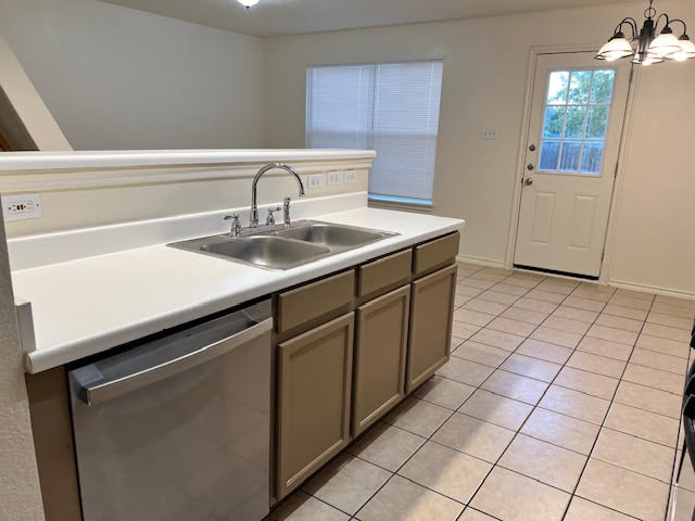 1012 Christopher Avenue, Unit B Round Rock, TX 78681 - Photo 12 of 34 Kitchen with light tile patterned flooring, dishwasher, light countertops, decorative light fixtures, and a chandelier