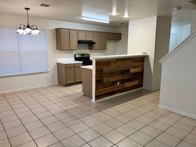 1012 Christopher Avenue, Unit B Round Rock, TX 78681 - Photo 15 of 34 Kitchen with light countertops, light tile patterned floors, a chandelier, and black range oven