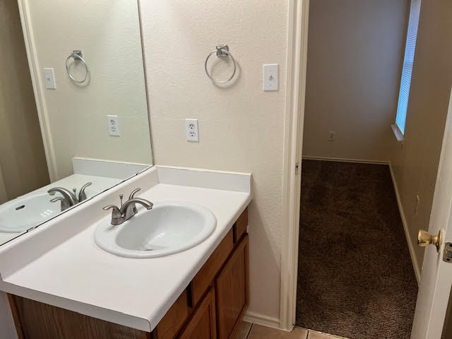 1012 Christopher Avenue, Unit B Round Rock, TX 78681 - Photo 23 of 34 Bathroom featuring vanity, light tile patterned flooring, and a textured wall