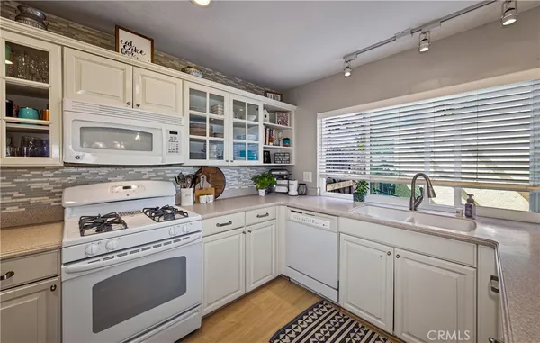 a kitchen with cabinets appliances a sink and a window