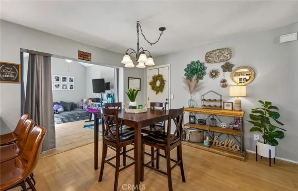 a view of a dining room and livingroom with furniture wooden floor a rug and a clock