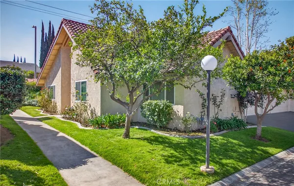 a front view of a house with a yard and potted plants