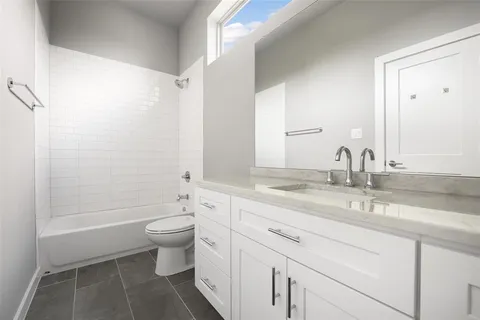 a bathroom with a granite countertop sink a toilet and a mirror