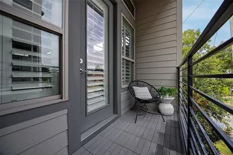 a view of a balcony with chairs and wooden floor