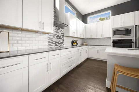 a kitchen with granite countertop white cabinets white stainless steel appliances and sink
