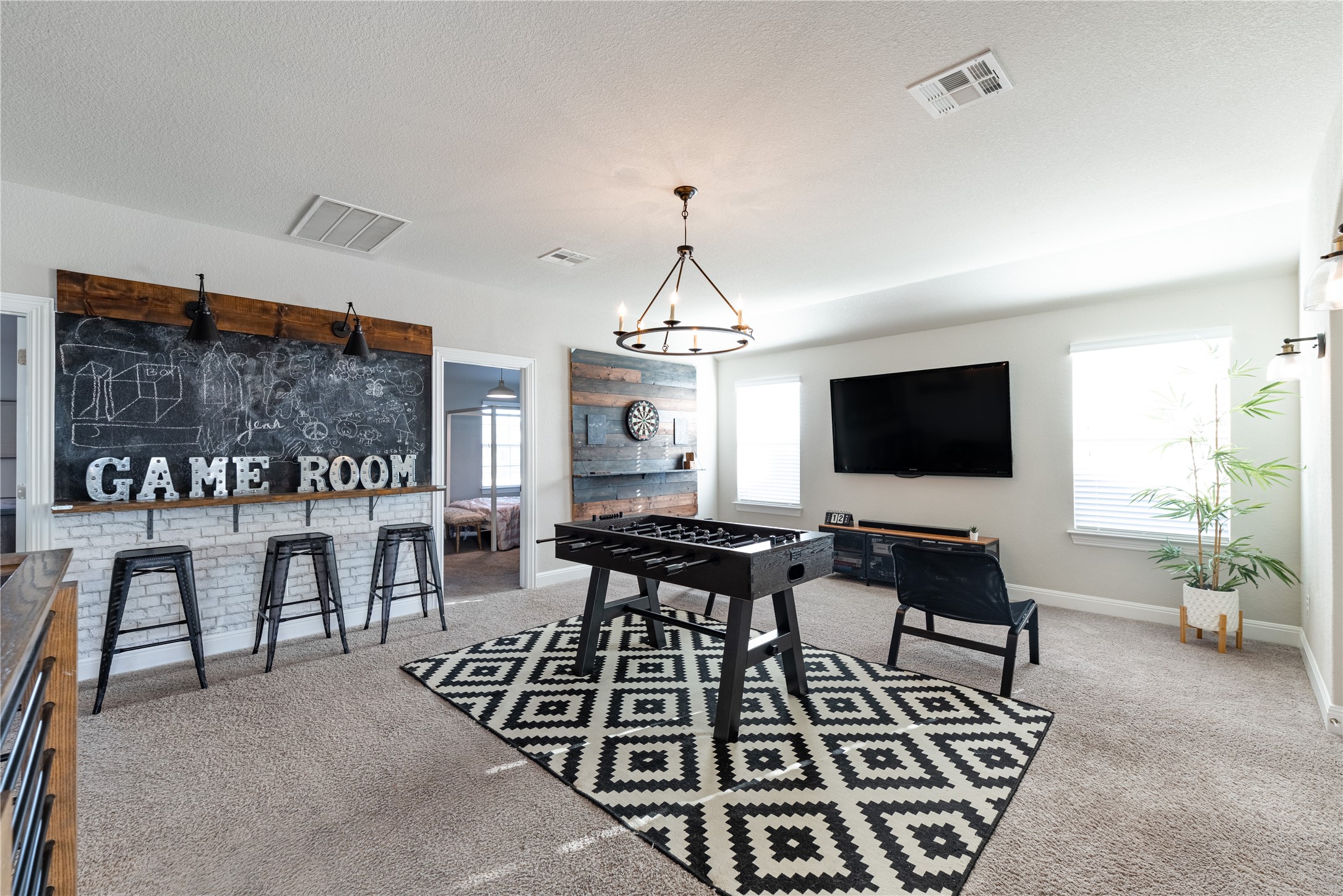 20524 Fairleaf Street Pflugerville, TX 78660 - Photo 18 of 35 Rec room featuring light carpet, a textured ceiling, and hanging lights