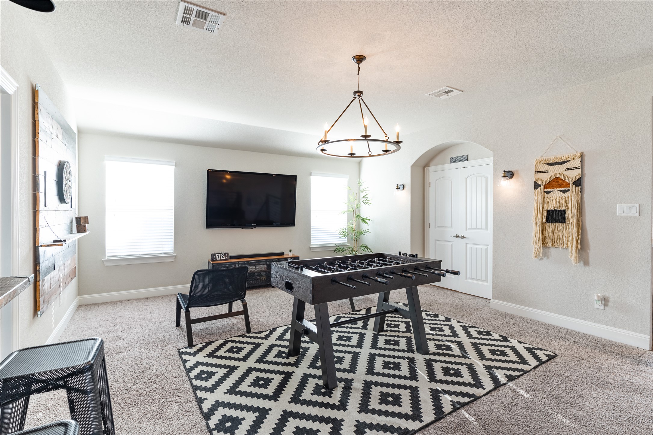 20524 Fairleaf Street Pflugerville, TX 78660 - Photo 20 of 35 Recreation room with arched walkways, light colored carpet, a textured ceiling, and suspended lighting