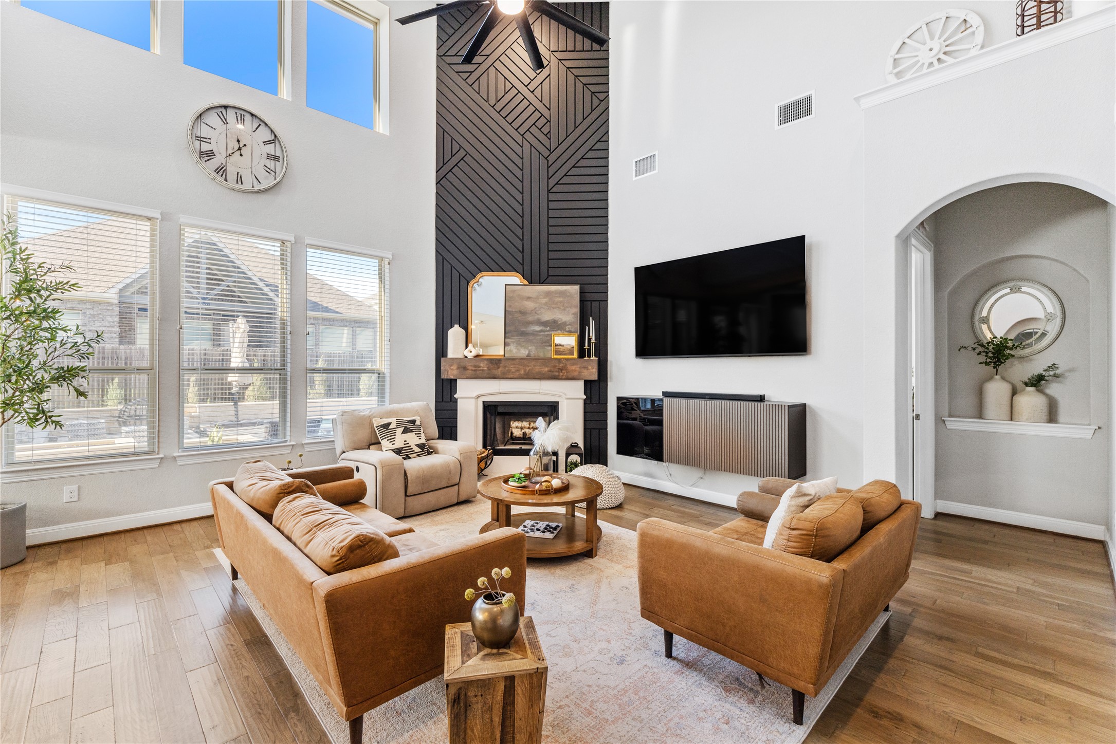 20524 Fairleaf Street Pflugerville, TX 78660 - Photo 2 of 35 Living area with a fireplace, wood finished floors, a high ceiling, arched walkways, and ceiling fan