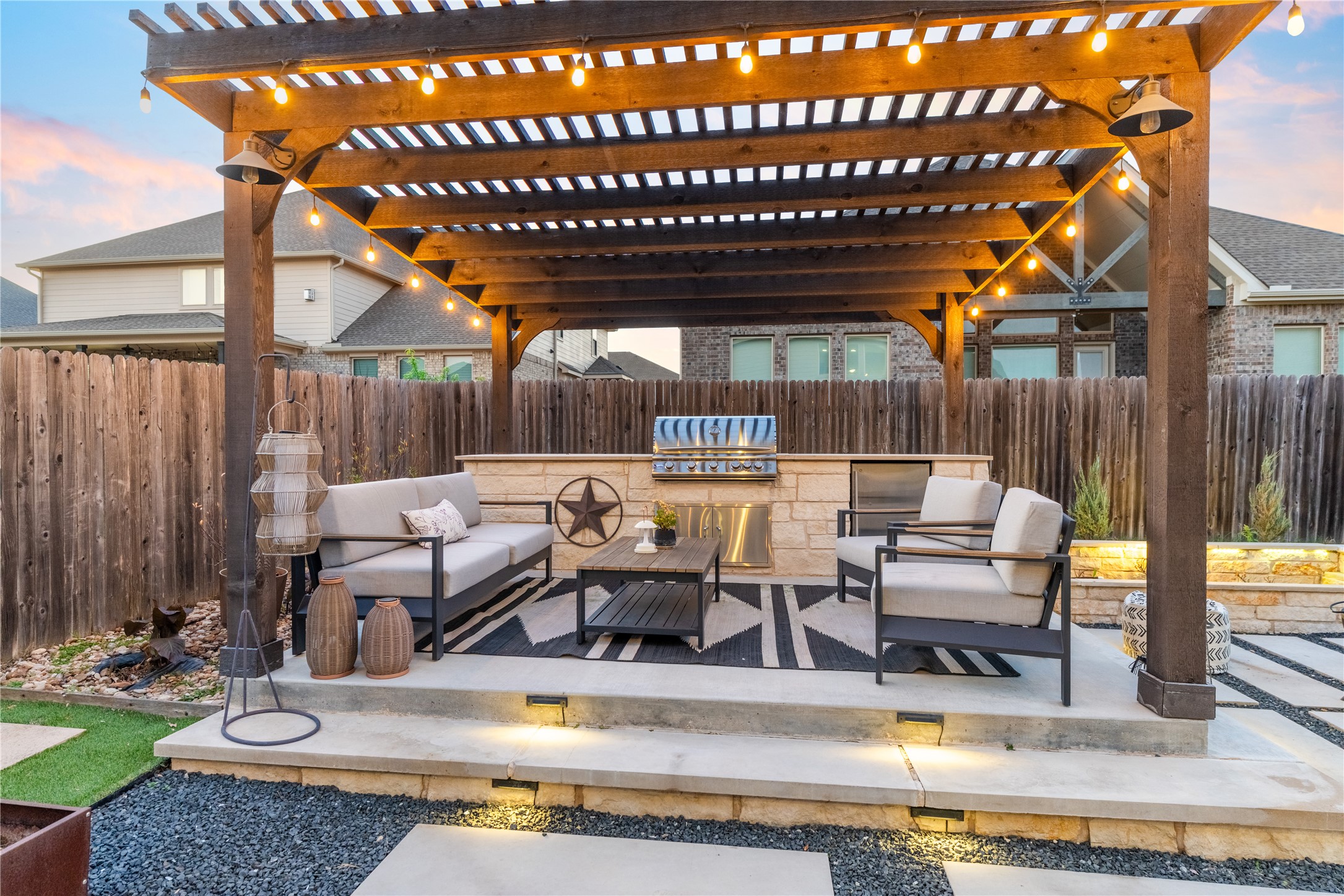 20524 Fairleaf Street Pflugerville, TX 78660 - Photo 29 of 35 Patio terrace at dusk featuring a patio, a fenced backyard, an outdoor kitchen with living area, and a pergola