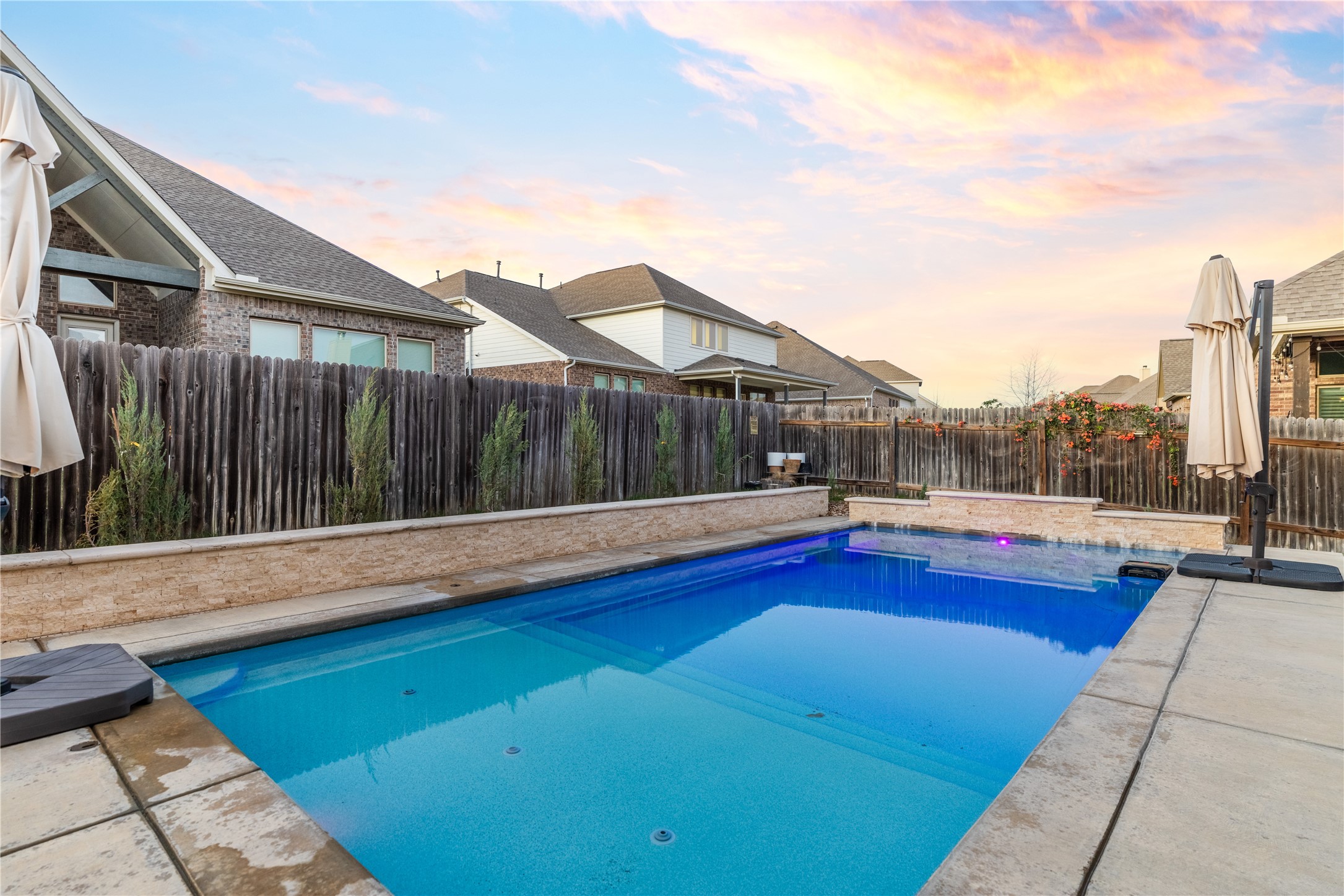 20524 Fairleaf Street Pflugerville, TX 78660 - Photo 30 of 35 Pool at dusk featuring a patio and a fenced backyard
